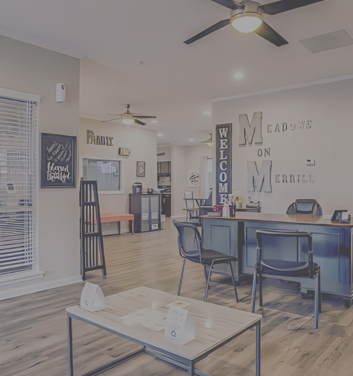 a living room with a ceiling fan and a table at The Meadows on Merrill